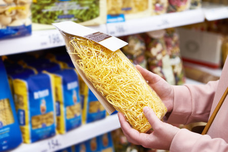 Woman buyer with a package pasta in the shopの写真素材