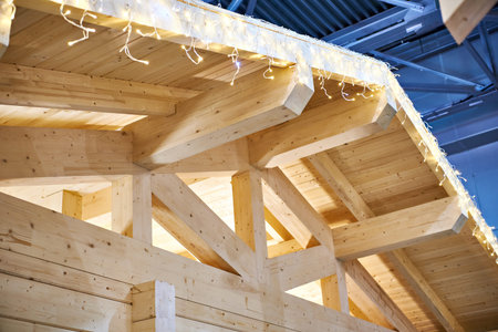 Frame of a wooden house with a festive light garland