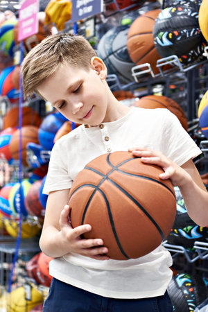 Boy with basketball ball in sport storeの写真素材