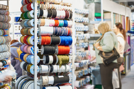 Woman shoppers choose fabric goods in textile storeの写真素材