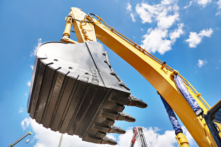 Excavator bucket hydraulics on sky background