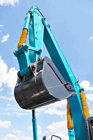 Excavator bucket hydraulics on sky background