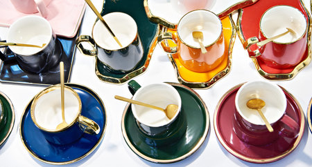 Colored porcelain tea mugs with spoons