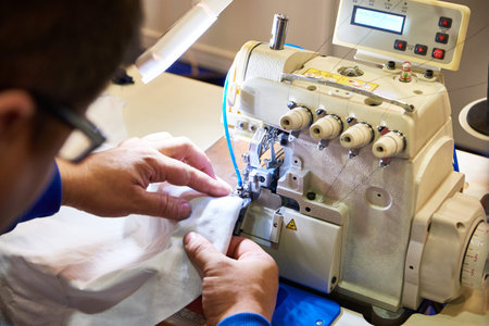 Hands of a tailor and a sewing machine