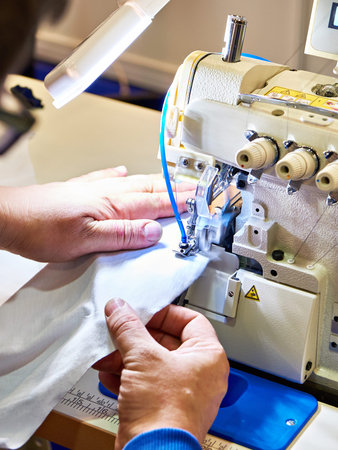 Hands of a tailor and a sewing machine