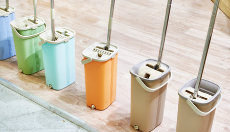 Mops with plastic buckets in market