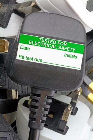 plan view of plugs  Blurred background of  three pin plugs with top of plug  with test stickerの写真素材