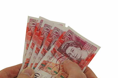 Offering a handful of money   Male hands holding several  fifty pound  notes isolated on a white backgroundの写真素材