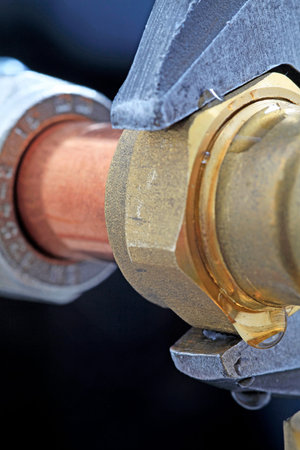 water leak â€“ An adjustable wrench adjusting a leaking compression joint on a black...