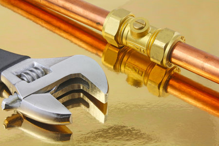 Plumber  pipework â€“ An adjustable wrench and  15mm copper pipework ith a compression ball...