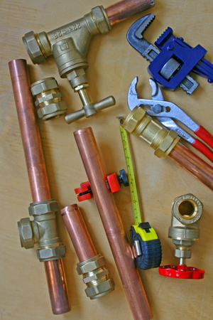 Plumber's pipes and fittings   â    Random mixture of copper pipe, tools and brass fittings ideal for use as a website header  backgroundの写真素材