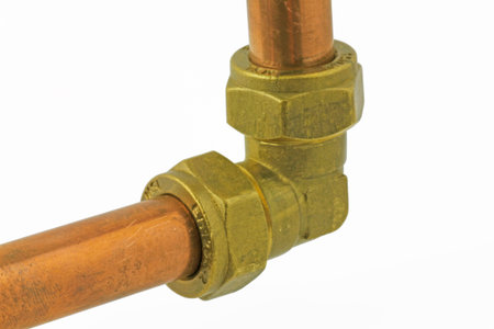 Plumbing pipework  â€“  A compression fitting elbow with pipework isolated on a white...