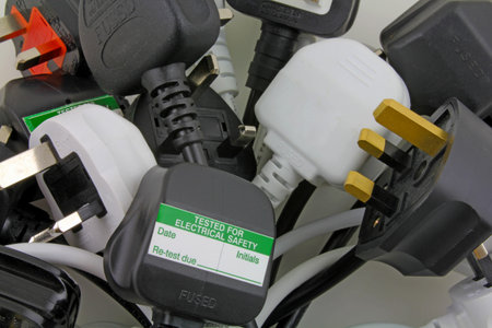 plan view of plugs â€“ Blurred background of  three pin plugs with top of plug  with test...