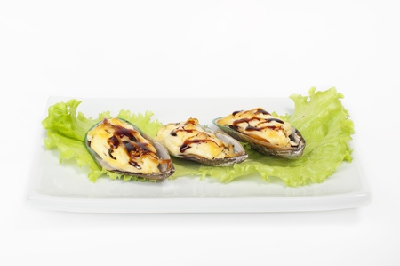 Mussels on a plate with lettuce and lemonの写真素材