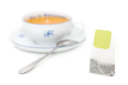 Close up tea bag on background is blurred mug of teaの写真素材