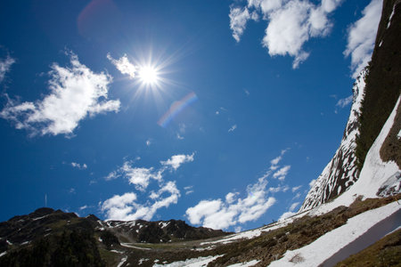 Blue sky with sun and clouds.