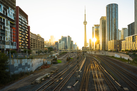 View of Toronto downtown, CN tower  in the middle and sun reflection over the railway tracks at sunriseの写真素材