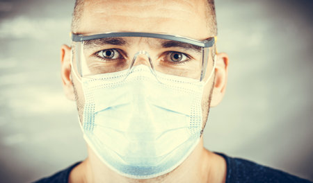 Doctor in a protective mask and glasses. Man protected against the virus. Hero of the first front in the fight against the epidemic.の写真素材