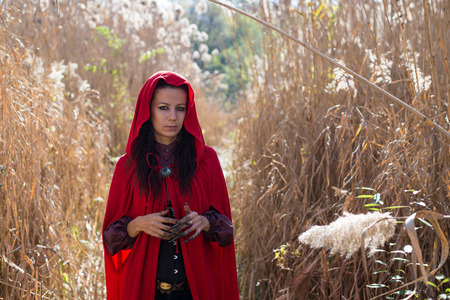 Girl in a red cloak in the lap of natureの写真素材