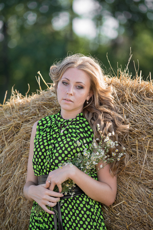 Pretty young girl on a haystackの写真素材