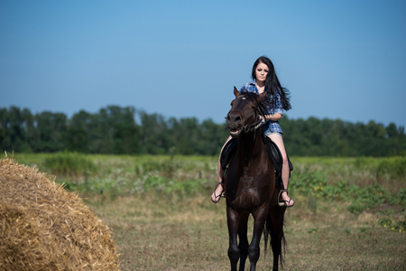 Young beautiful girl with a horse on natureの写真素材