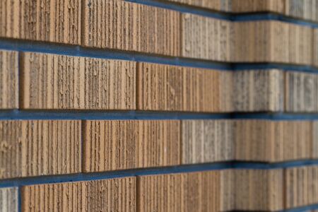 A brown brick wall from an angle that fades into a blurred background.の写真素材