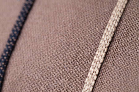 A macro shot of brown fabric on a pillow with one dark and one light brown line.の写真素材