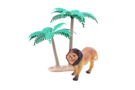 A small toy lion with trees ioslated on a white background.の写真素材