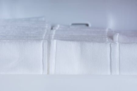 A macro shot of white cotton swabs lined up in a bathroom cabinet shelf.の写真素材