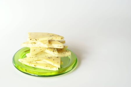 sliced cheese on the green plate close-upの写真素材
