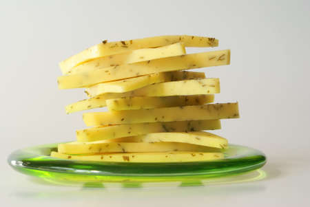 sliced cheese stack close-up on the green transparent plateの写真素材