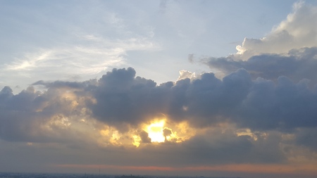 sun light shine through the huge grey cloud, look like a volcanoの写真素材