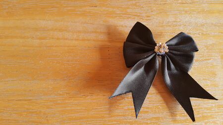 Elegant black bow on the wooden floor.の写真素材