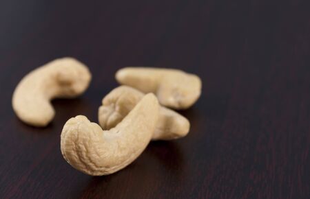 close up of cashew nut scattered on black wooden backgroundの写真素材
