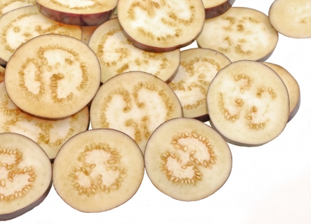 close up top view of sliced eggplant fruit piled on whiteの写真素材