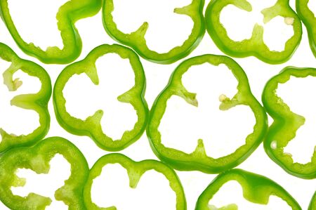 close up of green capsicum slices arranged on white backgroundの写真素材