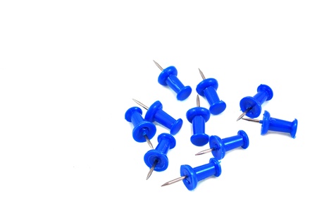 close up of blue push pins scattered on white の写真素材