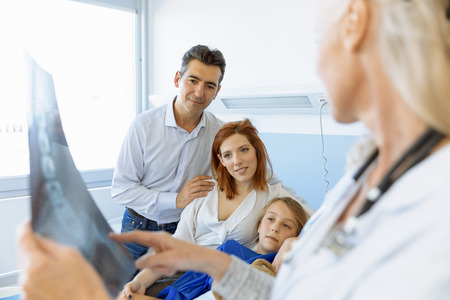 Pediatrician Visiting Parents And Child In Hospital Bedの写真素材