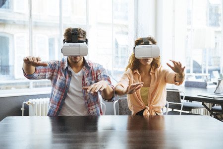 Entrepreneurs testing virtual reality technology with colleague in office.の写真素材