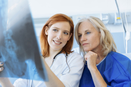 Doctor showing xray to a senior patient in hospitalの写真素材