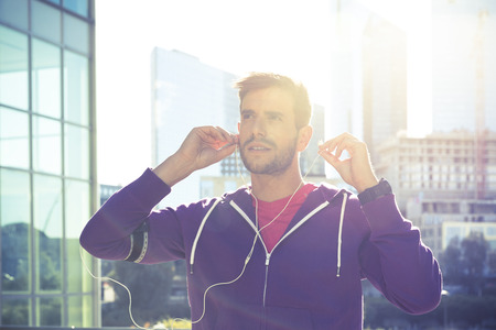 athlete with earphones running in the city
