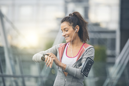 Female runner looking at her sport watch. Measuring heart rateの写真素材