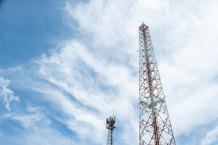Telecommunication tower with blue sky and white cloud background, telecommunication concept