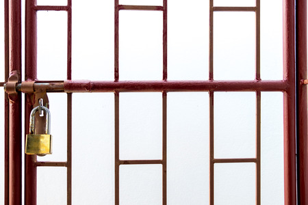 Red wrought iron window frame. The yellow key is locked. Isolate white backgroundの写真素材