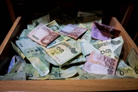 Many banknotes are inside the drawerの写真素材