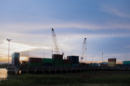 Crane transport container docks area silhouette with sunset backgroundの写真素材