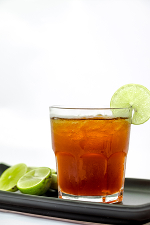 Glass of ice tea with lemon on white backgroundの写真素材