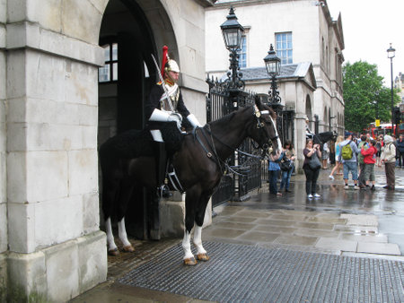 London, UK â July 03, 2008: Tourists and passersby look and photograph two cavalrymen of the Blues and Royals cavalry regiment at entrance to the Horse Guards in London. Urban scene on summer day.のeditorial素材
