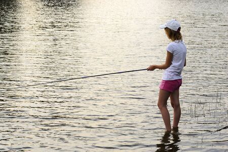 Girl fishing in a lakeの写真素材
