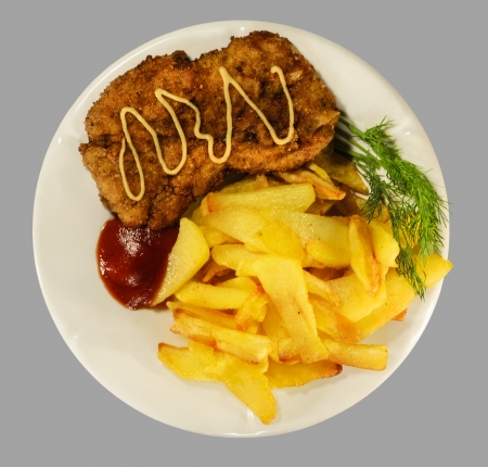 French fries with chicken chops on the white plate. Isolaten on the gray background.の写真素材